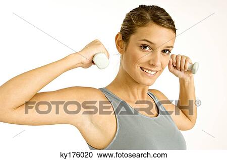 Portrait of a young woman exercising with dumbbells View Large Photo Image Stock Image - Portrait of a young woman exercising with dumbbells. Fotosearch