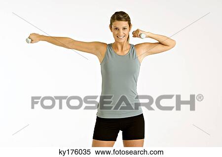 Portrait of a young woman exercising with dumbbells View Large Photo Image Stock Photography - Portrait of a young woman exercising with dumbbells. Fotosearch