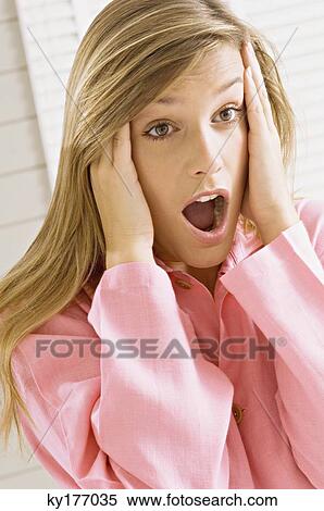 Stock Photography - Close-up of a young woman shouting in shock. Fotosearch