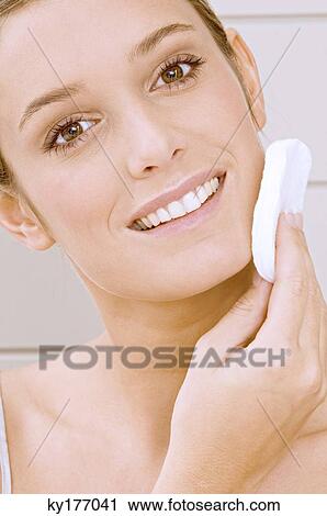 Portrait of a young woman applying face powder View Large Photo Image Stock Image - Portrait of a young woman applying face powder. Fotosearch