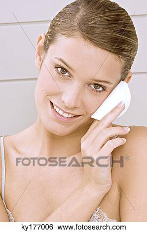 Portrait of a young woman applying face powder View Large Photo Image Stock Photograph - Portrait of a young woman applying face powder. Fotosearch