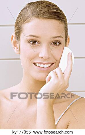 Portrait of a young woman applying face powder View Large Photo Image Stock Photography - Portrait of a young woman applying face powder. Fotosearch