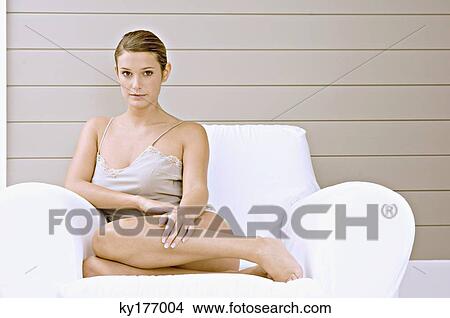 Portrait of a young woman sitting in an armchair View Large Photo Image Picture - Portrait of a young woman sitting in an armchair. Fotosearch