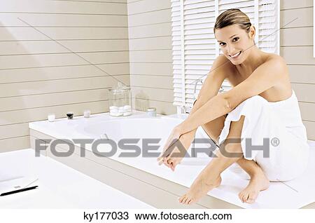 Portrait of a young woman sitting on a bathtub and smiling View Large Photo Image Stock Image - Portrait of a young woman sitting on a bathtub and smiling. Fotosearch