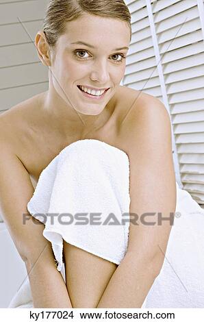 Portrait of a young woman wrapped in a bath towel and smiling View Large Photo Image Picture - Portrait of a young woman wrapped in a bath towel and smiling. Fotosearch