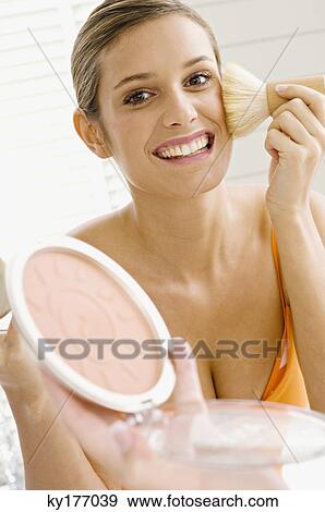 Reflection of a young woman applying make-up on her face View Large Photo Image Stock Photo - Reflection of a young woman applying make-up on her face. Fotosearch