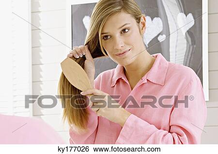 Reflection of a young woman brushing her hair View Large Photo Image Stock Photograph - Reflection of a young woman brushing her hair. Fotosearch