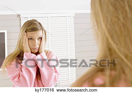 Reflection of a young woman in a mirror looking sad View Large Photo Image Stock Photograph - Reflection of a young woman in a mirror looking sad. Fotosearch