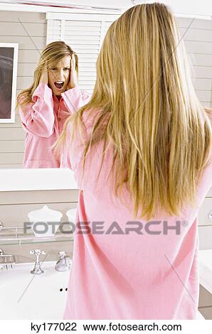 Reflection of a young woman looking in mirror and shouting View Large Photo Image Stock Image - Reflection of a young woman looking in mirror and shouting. Fotosearch