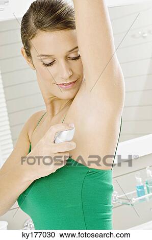 Side profile of a young woman applying deodorant on her underarm View Large Photo Image Stock Image - Side profile of a young woman applying deodorant on her underarm. Fotosearch