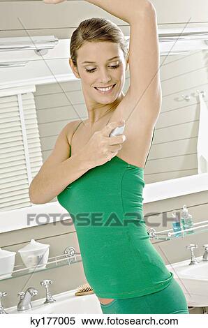 Side profile of a young woman applying deodorant on her underarm View Large Photo Image Stock Photography - Side profile of a young woman applying deodorant on her underarm. Fotosearch