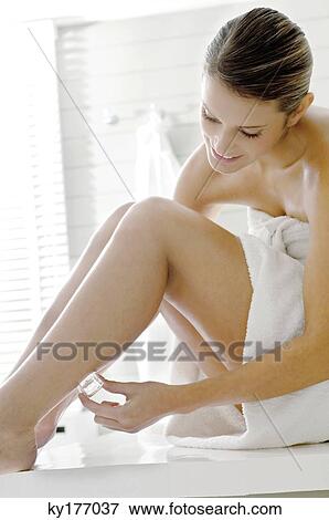 Young woman rubbing ice cube on her leg View Large Photo Image Stock Photo - Young woman rubbing ice cube on her leg. Fotosearch