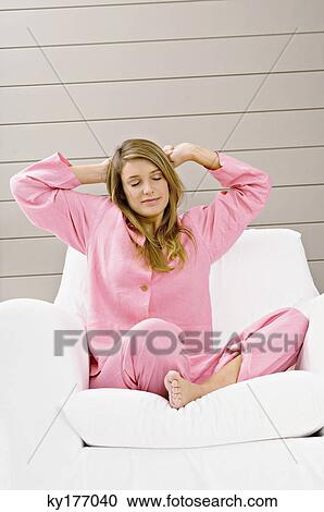Young woman sitting in an armchair and stretching her arms View Large Photo Image Stock Image - Young woman sitting in an armchair and stretching her arms. Fotosearch