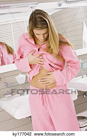 Young woman touching her abdomen View Large Photo Image Stock Image - Young woman touching her abdomen. Fotosearch