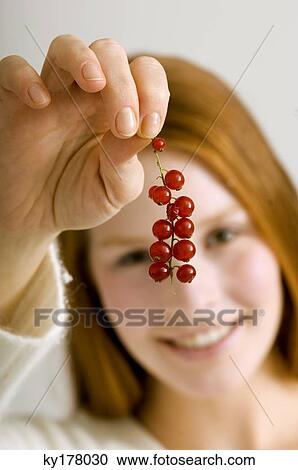 Close-up of a young woman holding a bunch of red currants View Large Photo Image Stock Image - Close-up of a young woman holding a bunch of red currants. Fotosearch