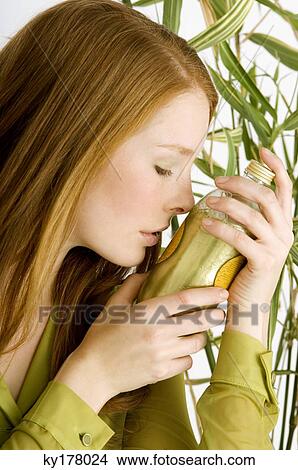Close-up of a young woman smelling a bottle of aromatherapy oil View Large Photo Image Picture - Close-up of a young woman smelling a bottle of aromatherapy oil. Fotosearch