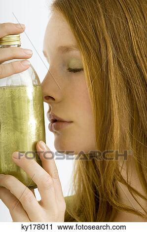 Close-up of a young woman smelling a bottle of aromatherapy oil View Large Photo Image Stock Image - Close-up of a young woman smelling a bottle of aromatherapy oil. Fotosearch
