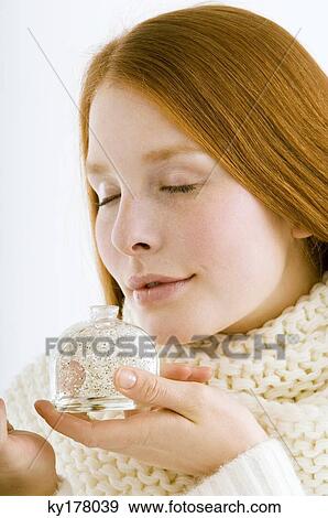Close-up of a young woman smelling perfume from a bottle View Large Photo Image Stock Photo - Close-up of a young woman smelling perfume from a bottle. Fotosearch