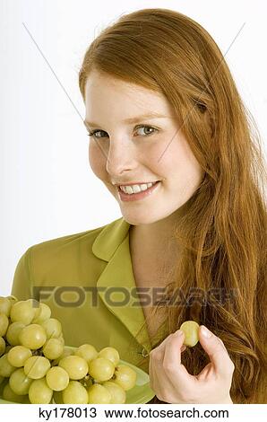 Portrait of a young woman eating grapes and smiling View Large Photo Image Stock Image - Portrait of a young woman eating grapes and smiling. Fotosearch