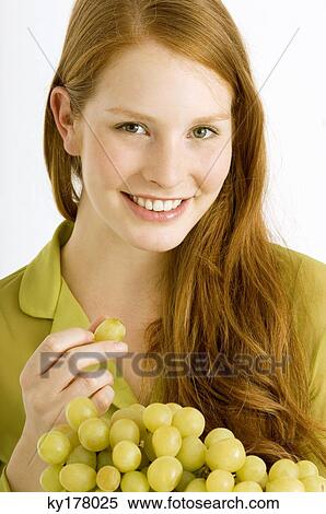 Portrait of a young woman eating grapes View Large Photo Image Stock Photography - Portrait of a young woman eating grapes. Fotosearch