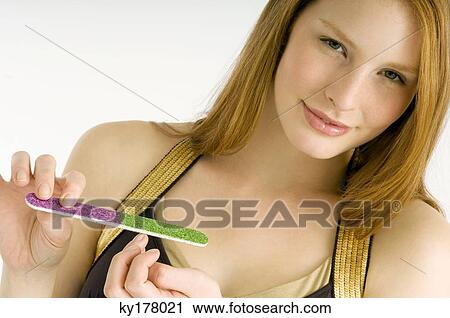 Portrait of a young woman filing her nails View Large Photo Image Stock Image - Portrait of a young woman filing her nails. Fotosearch