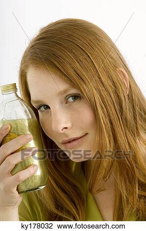 Portrait of a young woman holding a bottle of aromatherapy oil View Large Photo Image Stock Image - Portrait of a young woman holding a bottle of aromatherapy oil. Fotosearch