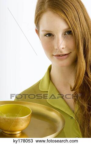Portrait of a young woman holding a bowl of massage oil on a plate View Large Photo Image Stock Image - Portrait of a young woman holding a bowl of massage oil on a plate. Fotosearch