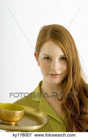 Portrait of a young woman holding a bowl of massage oil on a plate View Large Photo Image Stock Photo - Portrait of a young woman holding a bowl of massage oil on a plate. Fotosearch