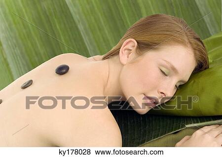 Young woman receiving a hot stone therapy View Large Photo Image Stock Photo - Young woman receiving a hot stone therapy. Fotosearch