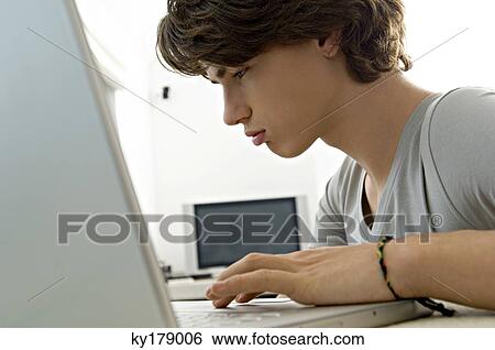 Close-up of a teenage boy using a laptop View Large Photo Image Stock Photograph - Close-up of a teenage boy using a laptop. Fotosearch