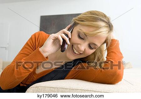 Close-up of a young woman talking on a mobile phone and smiling View Large Photo Image Stock Photograph - Close-up of a young woman talking on a mobile phone and smiling. Fotosearch
