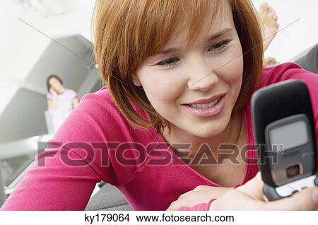 Picture - Close-up of a young woman using a mobile phone. Fotosearch