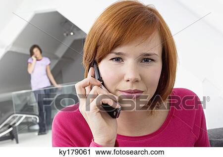 Close-up of a young woman using a mobile phone View Large Photo Image Stock Image - Close-up of a young woman using a mobile phone. Fotosearch