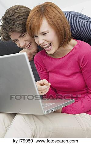 Close-up of two young women and a teenage boy looking at a laptop View Large Photo Image Stock Image - Close-up of two young women and a teenage boy looking at a laptop. Fotosearch