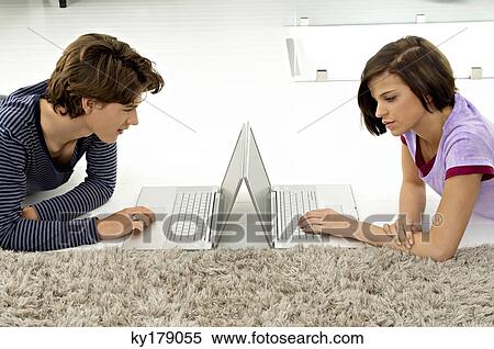 Side profile of a teenage boy and a young woman using laptops View Large Photo Image Stock Photography - Side profile of a teenage boy and a young woman using laptops. Fotosearch