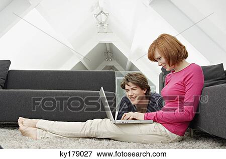 Side profile of a young woman and a teenage boy using a laptop View Large Photo Image Stock Photo - Side profile of a young woman and a teenage boy using a laptop. Fotosearch