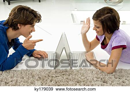 Side profile of a young woman and a teenage boy using laptops View Large Photo Image Stock Photo - Side profile of a young woman and a teenage boy using laptops. Fotosearch