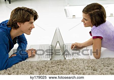 Side profile of a young woman and a teenage boy looking at each other and using laptops View Large Photo Image Stock Photography - Side profile of a young woman and a teenage boy looking at each other and using laptops. Fotosearch