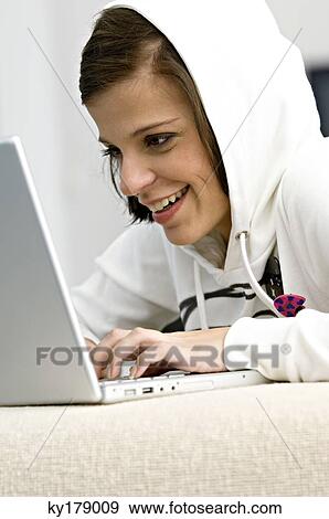 Side profile of a young woman using a laptop and smiling View Large Photo Image Stock Photo - Side profile of a young woman using a laptop and smiling. Fotosearch