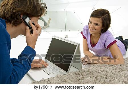 Teenage boy and a young woman looking at each other and using laptops View Large Photo Image Stock Photo - Teenage boy and a young woman looking at each other and using laptops. Fotosearch