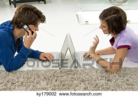 Teenage boy and a young woman using laptops View Large Photo Image Stock Image - Teenage boy and a young woman using laptops. Fotosearch