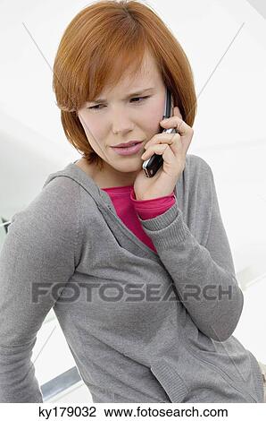Young woman talking on a mobile phone View Large Photo Image Stock Image - Young woman talking on a mobile phone. Fotosearch