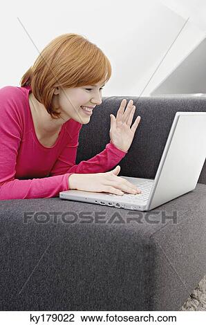 Young woman using a laptop and smiling View Large Photo Image Stock Image - Young woman using a laptop and smiling. Fotosearch