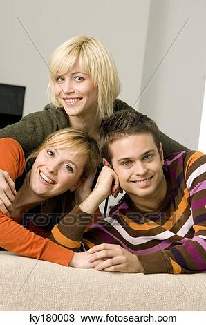 Portrait of a young man smiling with two young women View Large Photo Image Stock Image - Portrait of a young man smiling with two young women. Fotosearch
