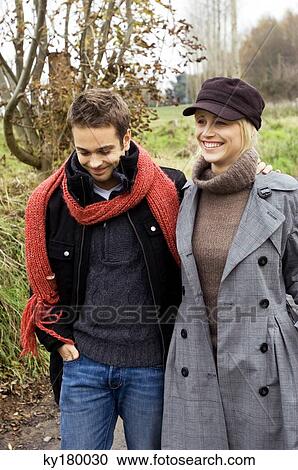 Stock Image - Young couple walking together and smiling. Fotosearch