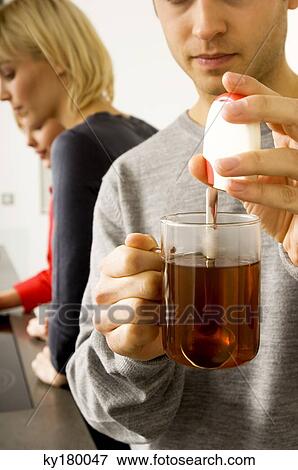 Stock Photo - Young man holding a cup of herbal tea. Fotosearch