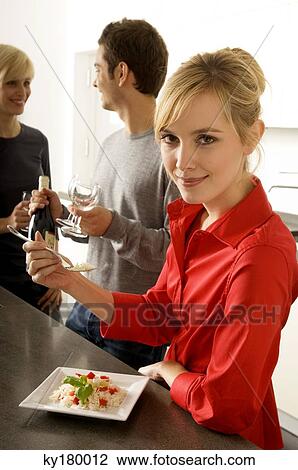 Stock Image - Young woman eating rice with a fork and smiling. Fotosearch