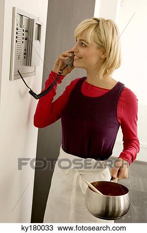 Young woman holding a saucepan and talking on the telephone View Large Photo Image Stock Image - Young woman holding a saucepan and talking on the telephone. Fotosearch