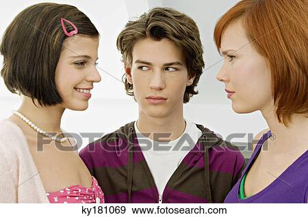 Close-up of a teenage boy with two young women View Large Photo Image Stock Photo - Close-up of a teenage boy with two young women. Fotosearch