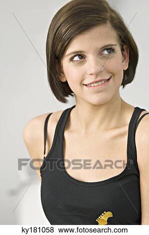 Stock Photo - Close-up of a young woman looking up and smiling. Fotosearch